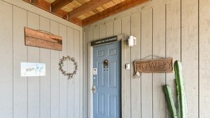 A rustic wooden door with a blue doorbell and a 'Home on the Range' sign above it. - Westcreek Ranch - No Stairs! (Branson West)