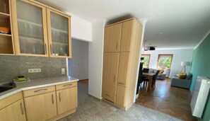 Una cocina moderna con armarios de madera, encimera de granito y un comedor con sofá y mesa.