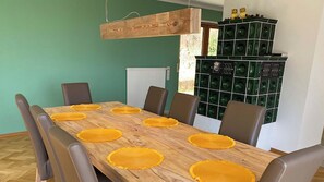 A dining area with a wooden table, six chairs, and yellow placemats.