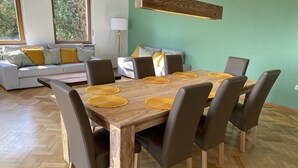 Uma sala de jantar com uma mesa de madeira, seis cadeiras e jogos americanos amarelos.