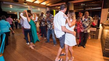 A dance floor with wooden flooring and a high ceiling.