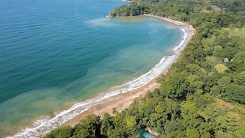 Na praia, areia branca, espreguiçadeiras, toalhas de praia