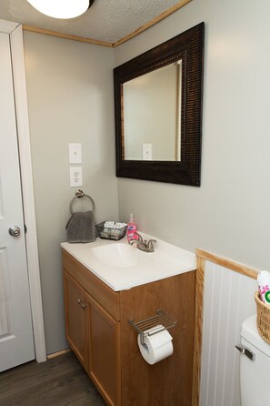 Een bad/douchecombinatie, een haardroger, handdoeken, zeep