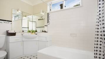 Bathtub, hair dryer, towels, shampoo