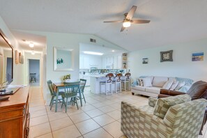 Relax in this open-plan living space with a kitchen area, dining table, and comfortable sofa.