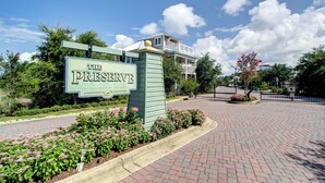 Un panneau indiquant « The Preserve at Graton Beach », avec un chemin pavé de briques et des parterres de fleurs aménagés.
