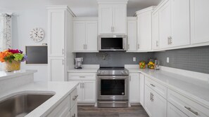 Enjoy cooking in this well-equipped kitchen with a coffee maker, preserved lemons, and a clock.