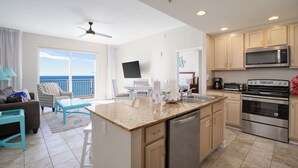 A modern kitchen with a central island, stainless steel appliances, and a view to the outside. - Penthouse! Beautiful Views! Newly Remodeled and Listed! (Panama City Beach)