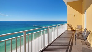 A balcony with a view of the ocean and a pier, furnished with metal chairs and a table. - Penthouse! Beautiful Views! Newly Remodeled and Listed! (Panama City Beach)