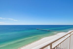 A beach with clear turquoise water, a sandy shore, and a pier extending into the sea. - Penthouse! Beautiful Views! Newly Remodeled and Listed! (Panama City Beach)