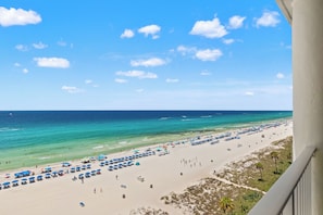 A beach with umbrellas and beach chairs, a clear sky, and the ocean. - Amazing Views! Recently Updated! Family Friendly Unit! Resort Pools! (Panama City Beach)