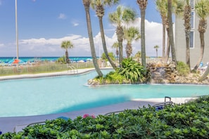 A pool area with clear blue water, surrounded by palm trees and a view of the beach. - Amazing Views! Recently Updated! Family Friendly Unit! Resort Pools! (Panama City Beach)