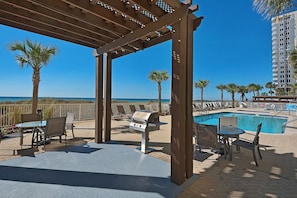 Relax by the pool and enjoy a meal at the outdoor patio, featuring a grill and comfortable seating.