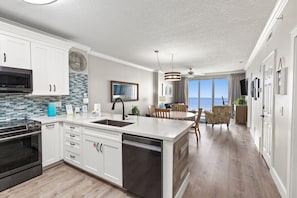 Enjoy meals in the spacious kitchen with a large island, double sink, and dining area with ocean views.