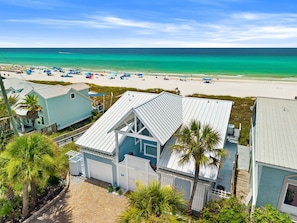 A coastal property with a beach view, a garage, and a fenced yard.
