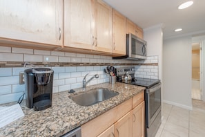 Enjoy cooking in this kitchen with a granite countertop, stainless steel sink, and microwave.