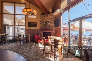 Enjoy a meal with a view of the water from this dining area featuring a fireplace and large window.