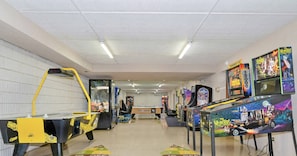Une salle d’arcade proposant divers jeux, notamment « The Munsters » et « Midnight Madness ».