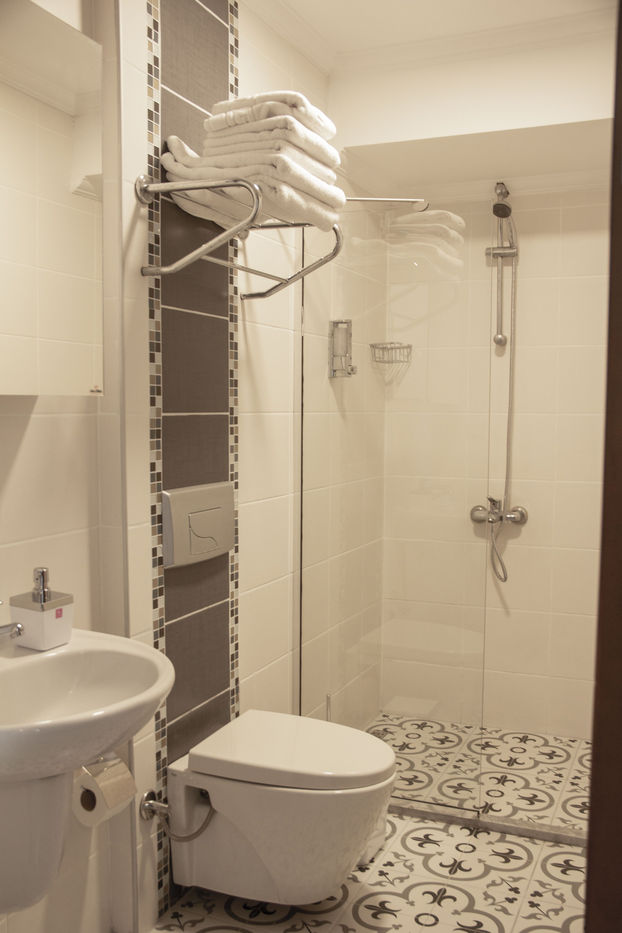 Un baño con inodoro, lavamanos y ducha.