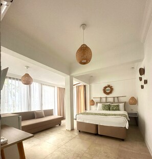 Une chambre moderne avec un grand lit, un canapé et un bureau.