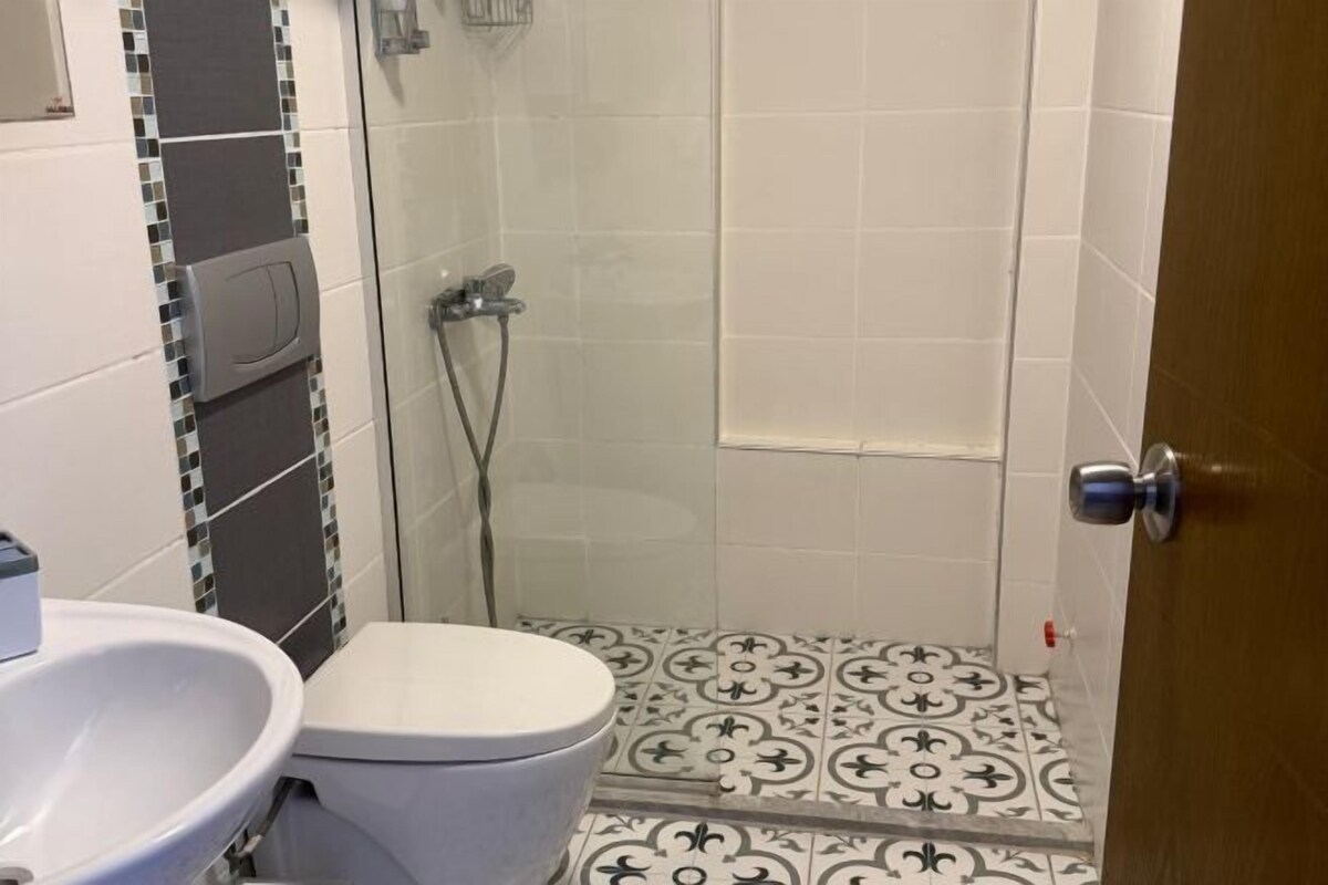 Une salle de bain avec des toilettes, un lavabo et une douche.