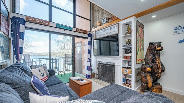 A cozy living room with a sofa, a fireplace, and a view of the outdoors. - Will O' The Wisp: 514C One Bedroom/One Bath (Oakland)