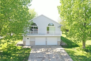 A two-story house with a front porch, garage, and a small balcony.