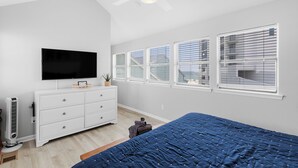 A bedroom with a bed, a dresser, a TV, and a ceiling fan. - 🏖️ Beachfront Family Fun – Pool, Switch & Karaoke (Gulf Shores)