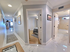 A hallway with a bed, a bathroom, and a view of the outside. - Ocean Way Unit  Two Bedroom Two Bath/Free wifi/Free Beach Equipment/Free Parking (Indian Rocks Beach)