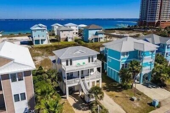 A coastal residential area with houses featuring balconies and a view of the ocean.