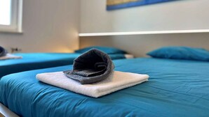 A hotel room with two beds, each with a blue bedspread and a white pillow. - Holiday apartment comfortably furnished just 20 m from the sea (Šilo)