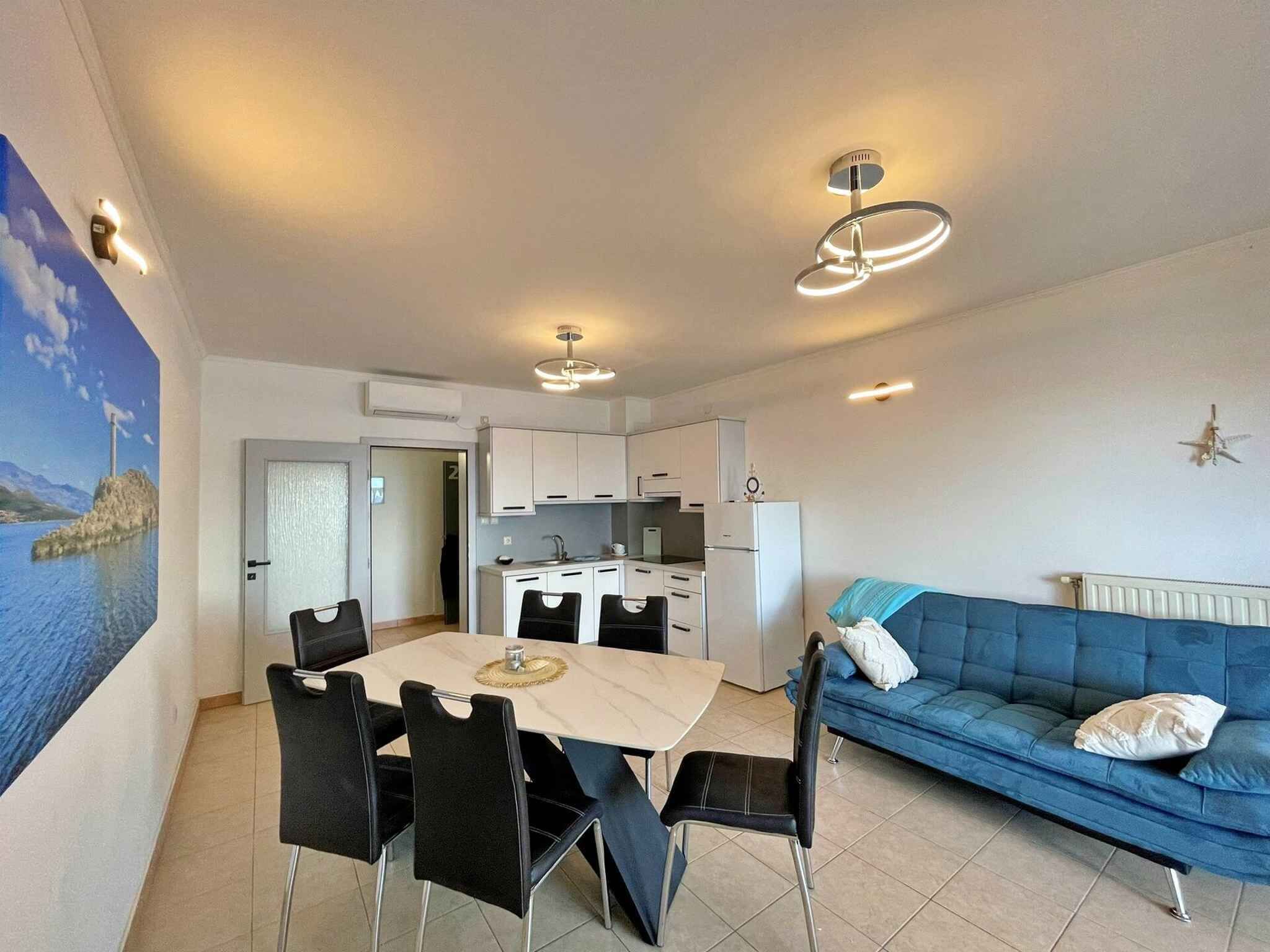 A compact living space with a dining area, kitchenette, and a sofa.
