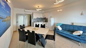 A compact living space with a dining area, kitchenette, and a sofa. - Holiday apartment comfortably furnished just 20 m from the sea (Šilo)