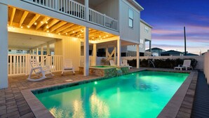 A swimming pool with a wooden deck, a covered seating area, and a view of a residential neighborhood. - Modern Luxury Home w/ Private Pool - Cherry Grove Beach (North Myrtle Beach)