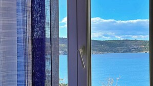 Una ventana con vistas a un cuerpo de agua y un paisaje montañoso.