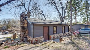 A small house with a stone chimney, a front door, and a small porch area. - Lakefront Eucha Escape w/ Views & Boat Slip! (Eucha)