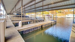 A covered dock area with wooden walkways and boats. - Lakefront Eucha Escape w/ Views & Boat Slip! (Eucha)