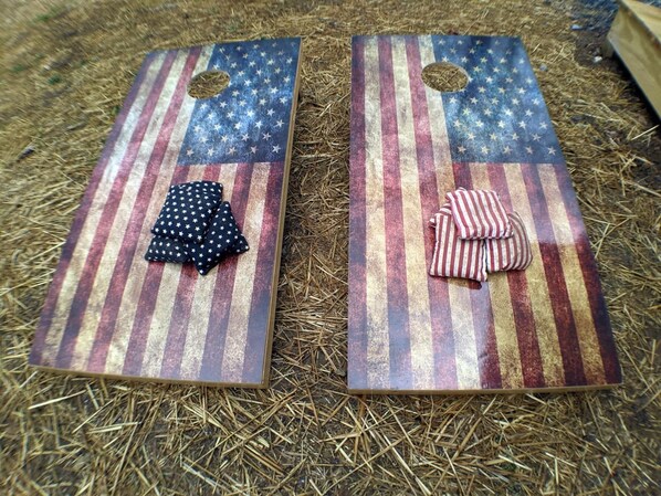 Two boards with American flag designs, one with a black polka dot cloth and one with a striped cloth.