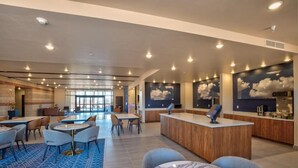 A modern hotel lobby with a pool area, seating arrangements, and a reception desk. - Scenic View Inn & Suites Moab (Moab)