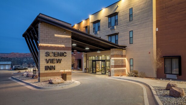 A hotel entrance with a sign reading "SCENIC VIEW INN," a covered walkway, and a parking area. - Scenic View Inn & Suites Moab (Moab)