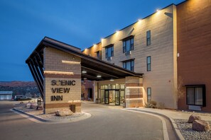 Entrada de hotel con un letrero que dice "SCENIC VIEW INN", un corredor cubierto y un área de estacionamiento.
