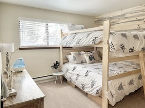 A bunk bed room with a window, a desk with a lamp, and a small plant. - Cozy Family Friendly Lodge, 2 Games Rooms, Hot Tub, EV Charger (Prescott)