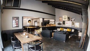 A modern interior with a dining area, sofa, and artwork on the walls. - Chamonix 10: Charming, Walk to Canyon Lodge (Mammoth Lakes)