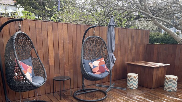 Two hanging chairs with cushions, a small round table, and a bench. - Derby Bank House Cabin- one bedroom with full kitchen. In the centre of town (Derby)