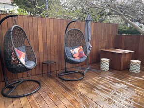 Two hanging chairs with cushions, a small round table, and a bench. - Derby Bank House Cabin- one bedroom with full kitchen. In the centre of town (Derby)