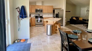 A modern kitchen with wooden cabinets, stainless steel appliances, and a central island. - Little Woods Outpost | Wifi, AC, Hot tub (Randle)