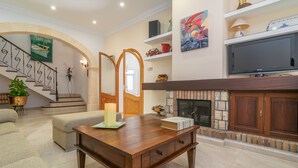A spacious living room with a fireplace, a wooden coffee table, and a television.