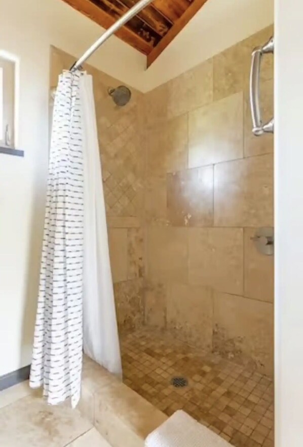 A shower area with a tiled floor and a shower curtain. - Escape to your private oasis (Hilo)