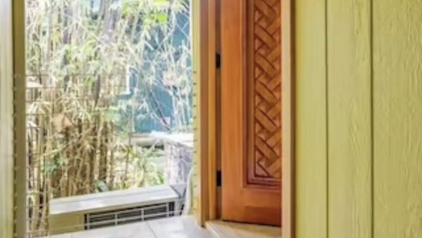 A corridor with a wooden ceiling, a green door with a lattice design, and a view of bamboo outside. - Escape to your private oasis (Hilo)