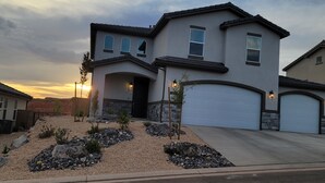 A two-story house with a garage, a landscaped front yard with rocks and small plants, and a sunset in the background. - Pool now open! Pickleball! Game Room! (Washington)